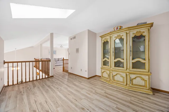 a view of a hallway with wooden floor and stairs