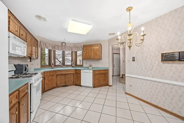 a large kitchen with stainless steel appliances a stove a sink dishwasher and a refrigerator