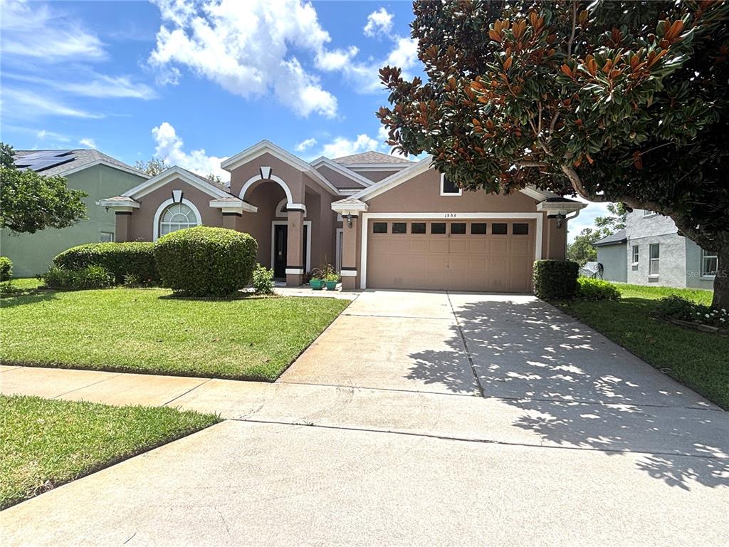 a front view of a house with a yard and garage