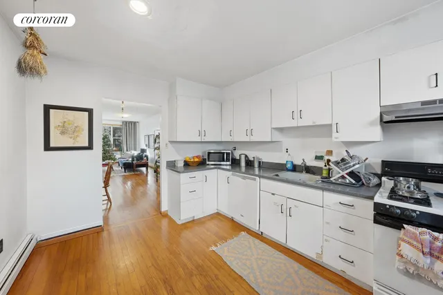 a dining room with wooden floor a chandelier a wooden table and chairs