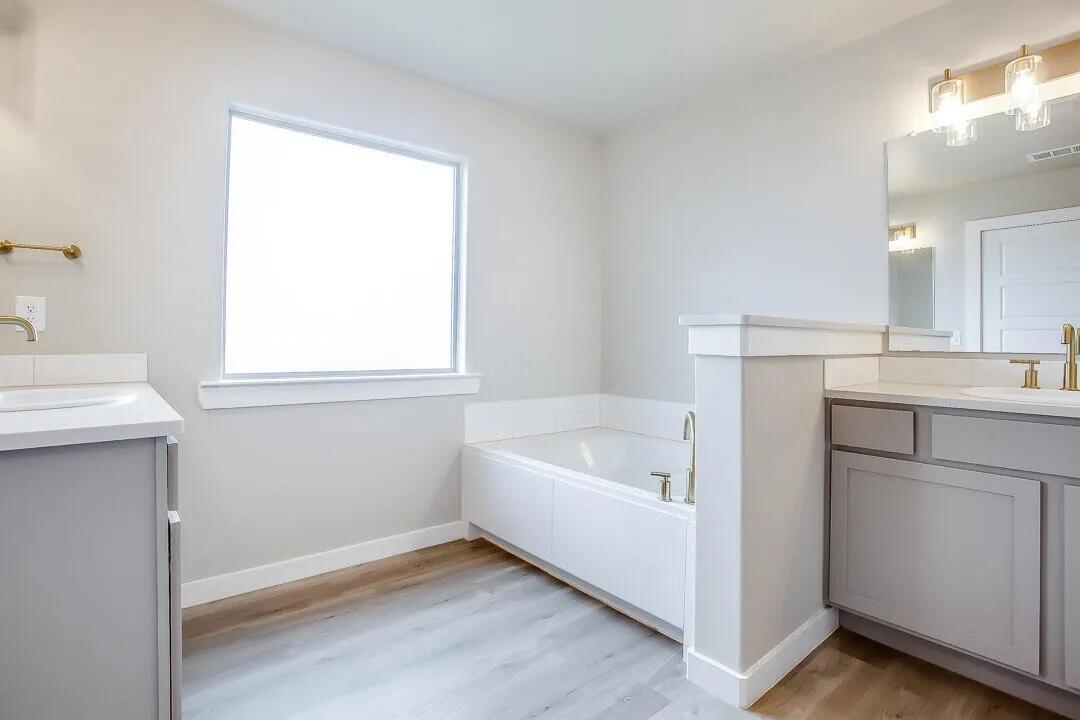 10502 Aberdeen Avenue Lubbock, TX 79424 - Photo 12 of 20 a bathroom with a tub sink and mirror