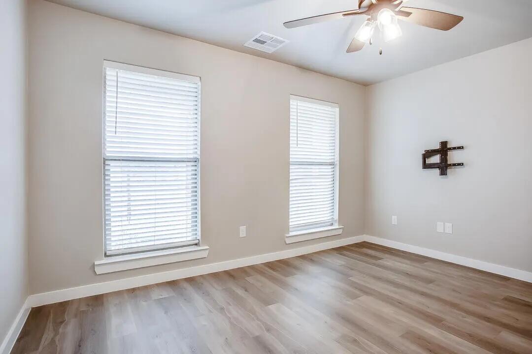 10502 Aberdeen Avenue Lubbock, TX 79424 - Photo 16 of 20 a view of an empty room with a window and wooden floor