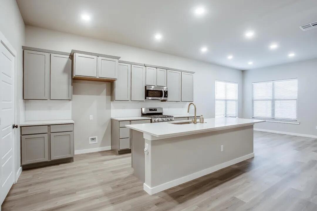 10502 Aberdeen Avenue Lubbock, TX 79424 - Photo 6 of 20 a kitchen with kitchen island granite countertop a sink cabinets and stainless steel appliances