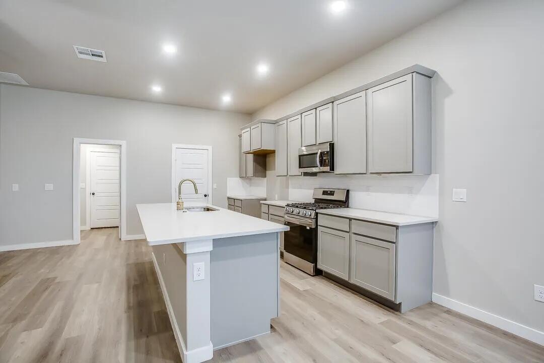 10502 Aberdeen Avenue Lubbock, TX 79424 - Photo 7 of 20 a kitchen with stainless steel appliances granite countertop a sink stove microwave and refrigerator