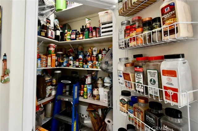 a store room with stainless steel appliances and a book shelf