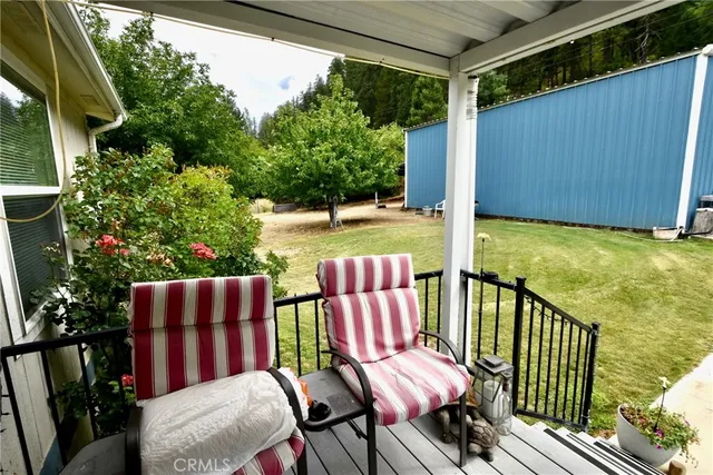 a view of a patio with table and chairs potted plants with wooden floor and fence