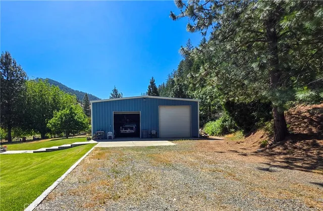 a view of a house with backyard and trees