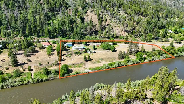 an aerial view of a house with a yard and lake view