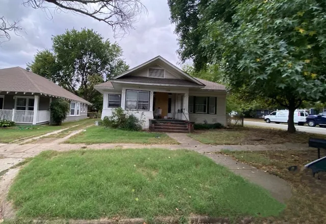a front view of a house with yard and green space