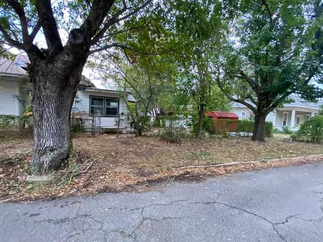 a backyard of a house with outdoor seating and trees