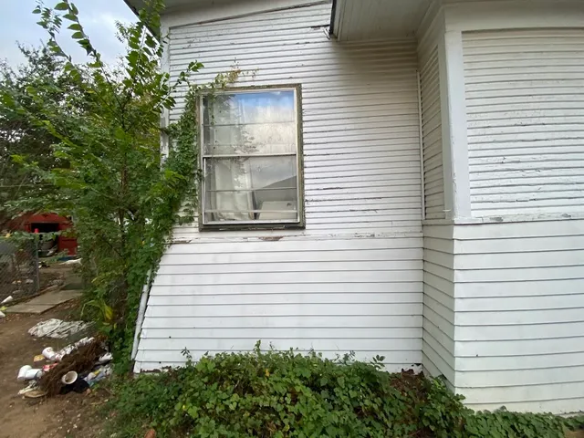 a view of a white house with a yard and garage