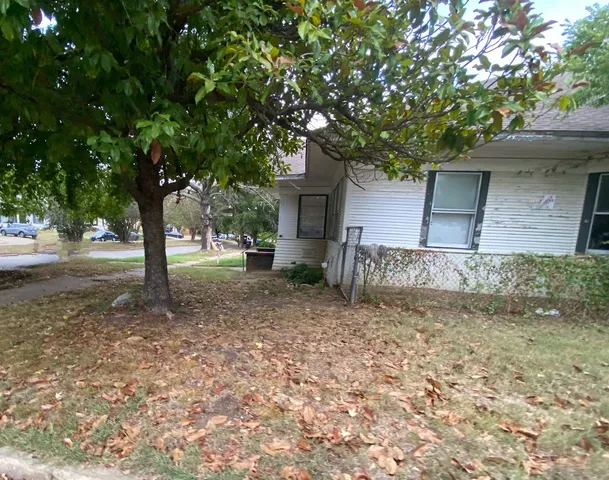 a front view of a house with a tree