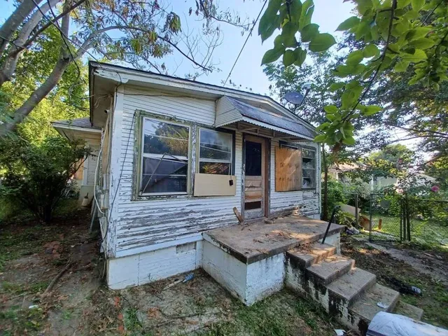 a view of house with backyard and outdoor seating