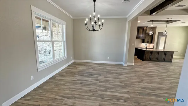 a view of empty room with window and wooden floor