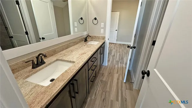a bathroom with a granite countertop sink a mirror and vanity