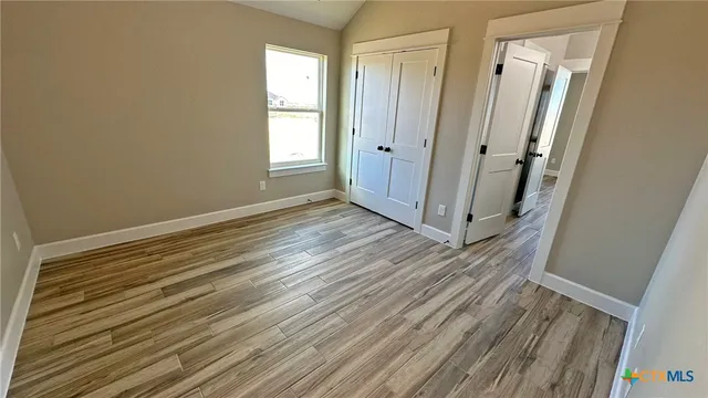 a view of a room with wooden floor and window