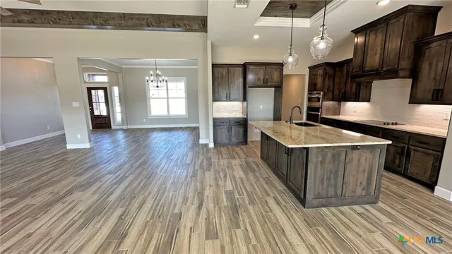a kitchen with a sink and wooden floor