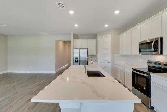 a kitchen with sink stove and refrigerator