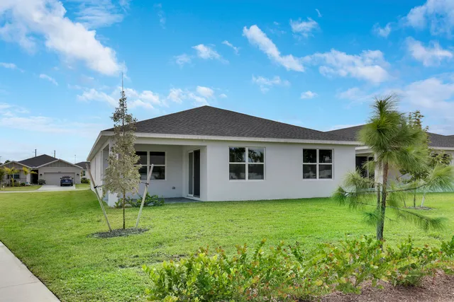 a house with green field in front of it