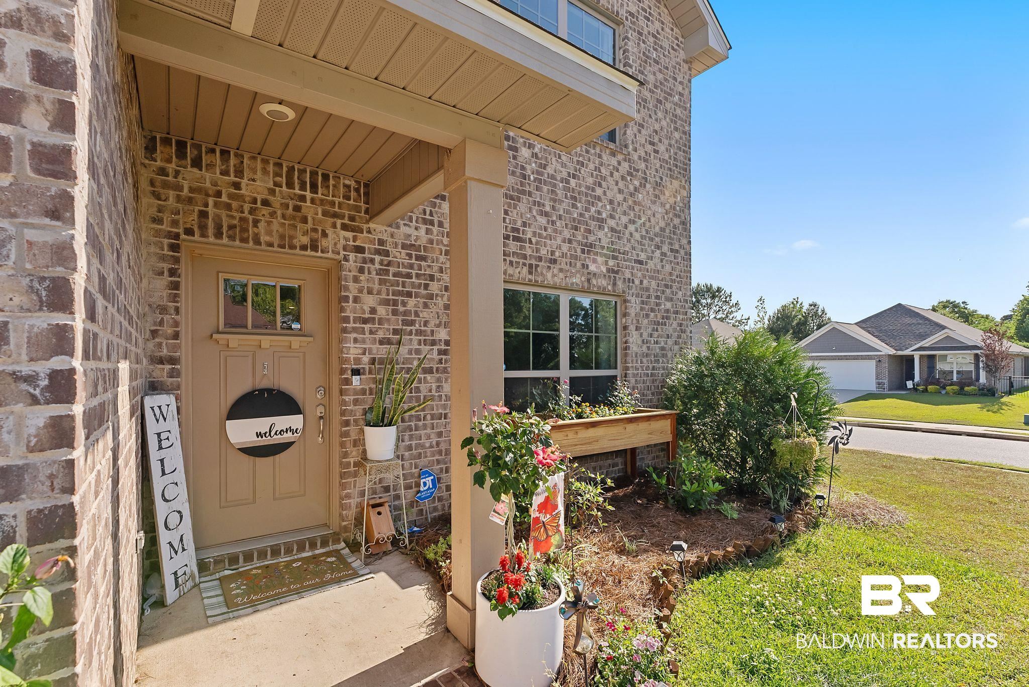 16607 Prado Loop Loxley, AL 36551 - Photo 4 of 46 Brick exterior with a covered entry and a concrete walkway