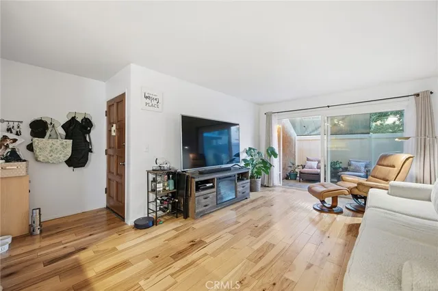 a living room with a large window wooden floor and furniture
