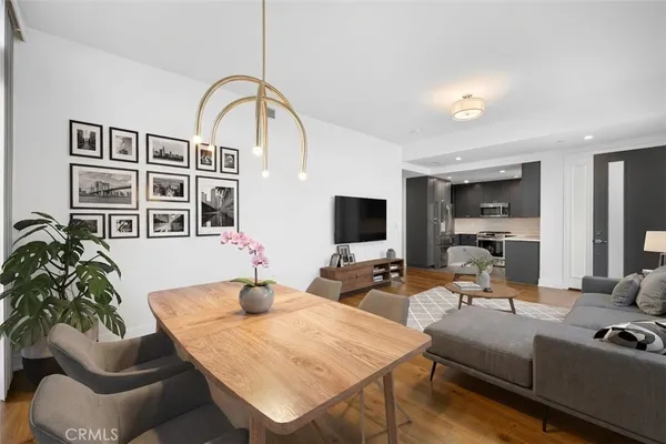 a view of a patio with couches table and chairs potted plants and large tree