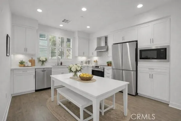 a living room with furniture two windows and a flat screen tv
