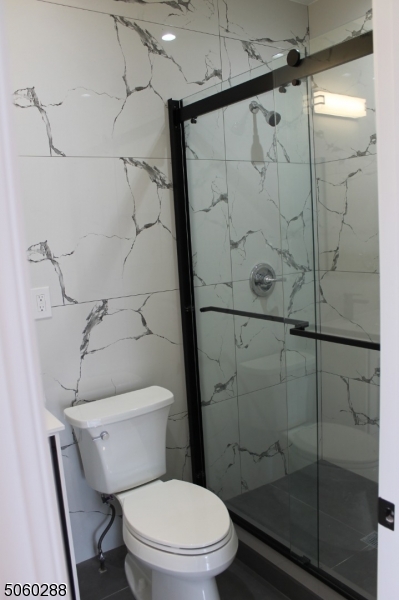 164 Main Street, Unit 2 Garfield, NJ 07026 - Photo 13 of 24 a white toilet sitting next to a bath tub shower
