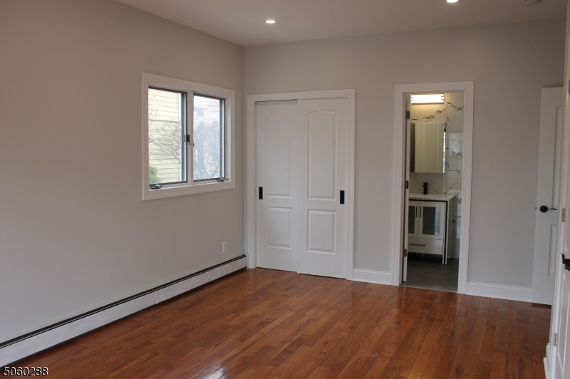164 Main Street, Unit 2 Garfield, NJ 07026 - Photo 15 of 24 an empty room with wooden floor and windows
