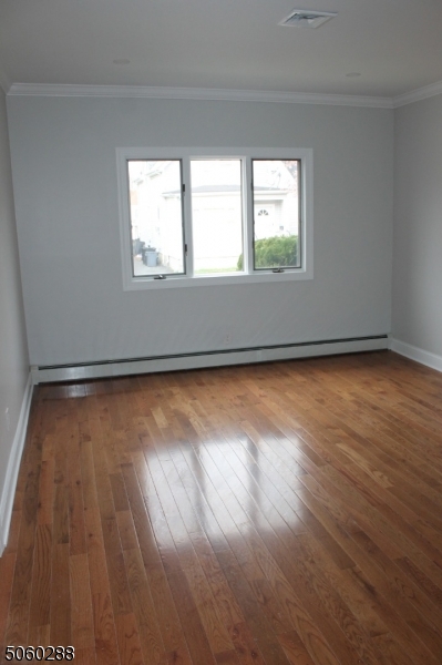164 Main Street, Unit 2 Garfield, NJ 07026 - Photo 3 of 24 a view of empty room with wooden floor and fan