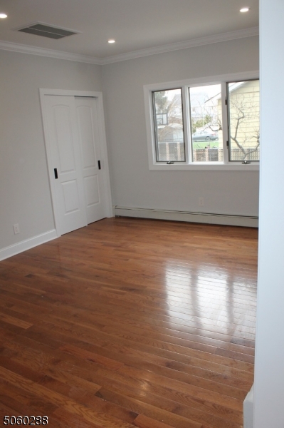 164 Main Street, Unit 2 Garfield, NJ 07026 - Photo 4 of 24 a view of an empty room with wooden floor and a window