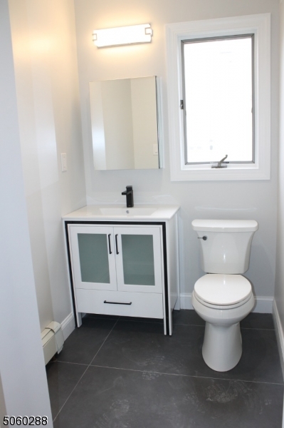 164 Main Street, Unit 2 Garfield, NJ 07026 - Photo 6 of 24 a bathroom with a toilet sink and mirror
