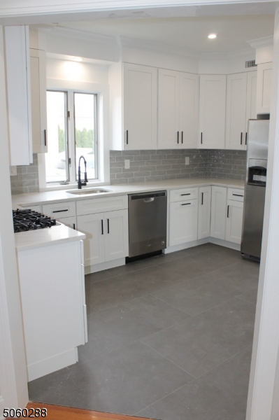 164 Main Street, Unit 2 Garfield, NJ 07026 - Photo 8 of 24 a kitchen with cabinets appliances a sink and a window