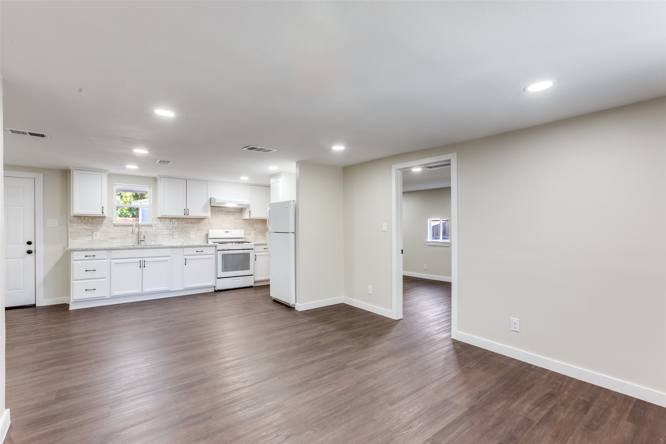 1118 Spur Street Austin, TX 78721 - Photo 4 of 21 A pristine culinary space with white cabinetry and ample counter surface defines this open-concept kitchen.