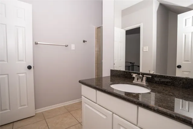 a bathroom with a granite countertop sink and a mirror