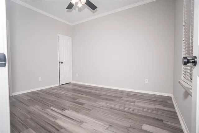 an empty room with wooden floor and chandelier fan