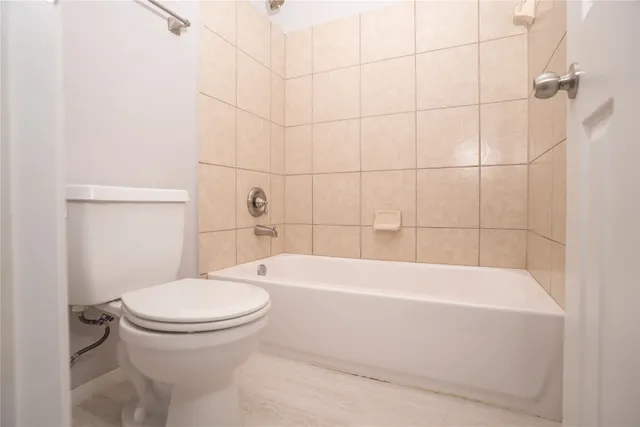 a bathroom with a toilet and a bath tub