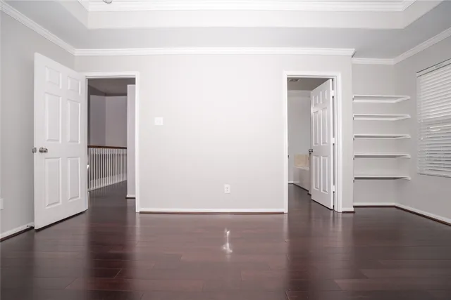 an empty room with wooden floor & windows