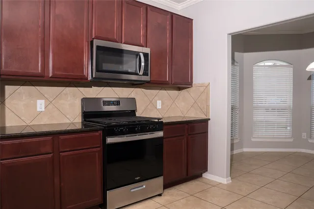 a kitchen with granite countertop wood cabinets and stainless steel appliances