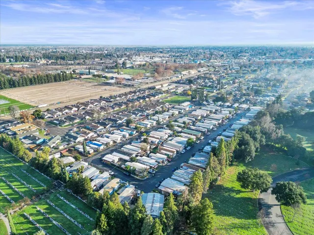 an aerial view of residential houses with outdoor space and trees