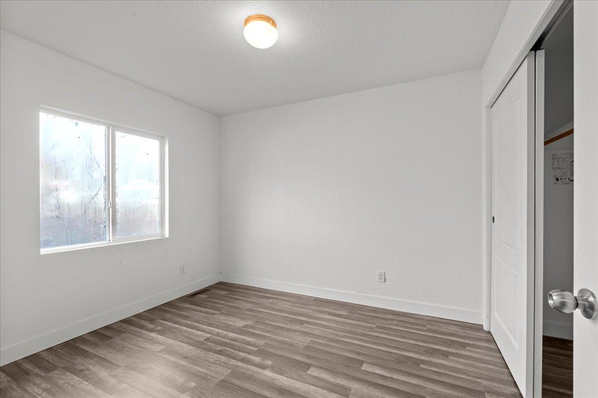 1249 Magic Sands Way Turlock, CA 95380 - Photo 9 of 13 an empty room with wooden floor and windows