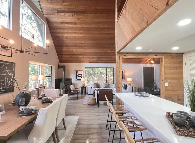 a living room with furniture a large window and potted plants
