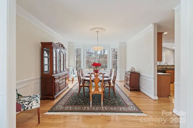 an aerial view of a residential houses with outdoor space and trees all around