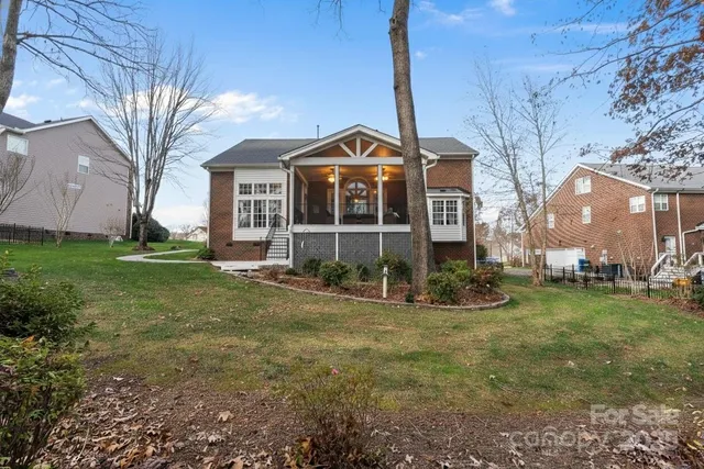 a kitchen with stainless steel appliances granite countertop a refrigerator a sink dishwasher a stove and a dining table with wooden floor