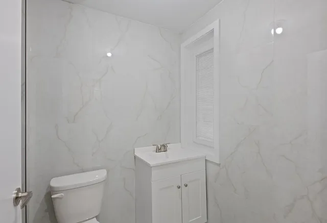 a white toilet sitting next to a white sink