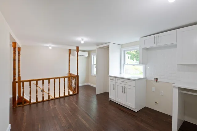 a view of a kitchen with wooden floor and a window