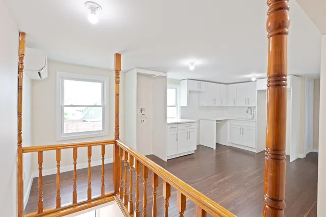 a kitchen with white cabinets and wooden floors
