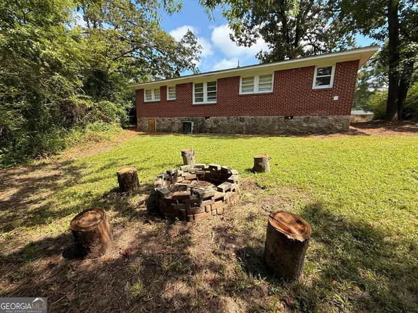 a view of a house with yard and sitting area