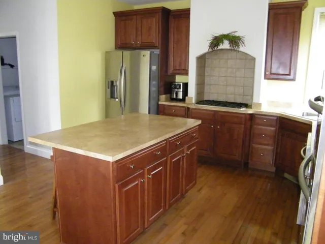 a kitchen with stainless steel appliances granite countertop a sink a microwave cabinets and wooden floor