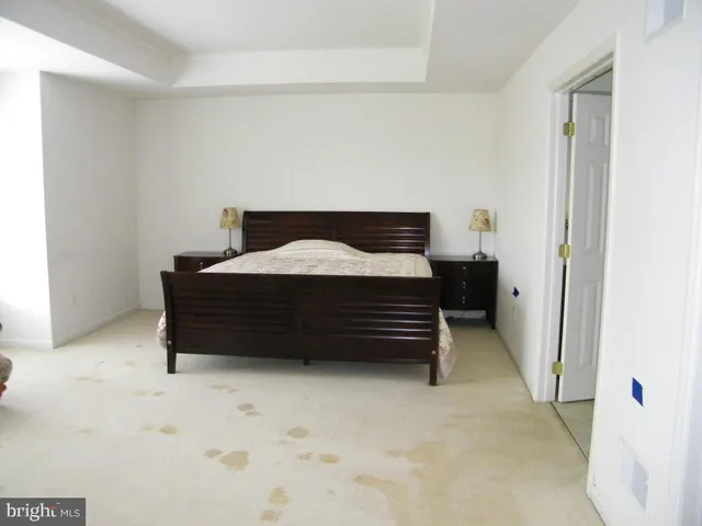 a bedroom with a bed a mirror and a window